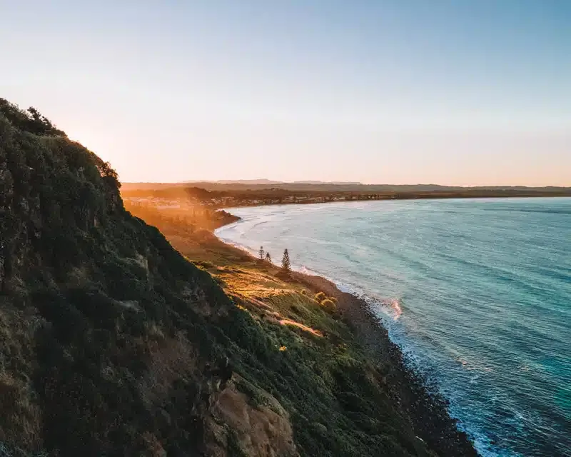 Clifftop view of a coastline at sunset, with ocean, beach, and golden sunlight - Rochdale Accounting & Business Advisory in Alstonville, NSW