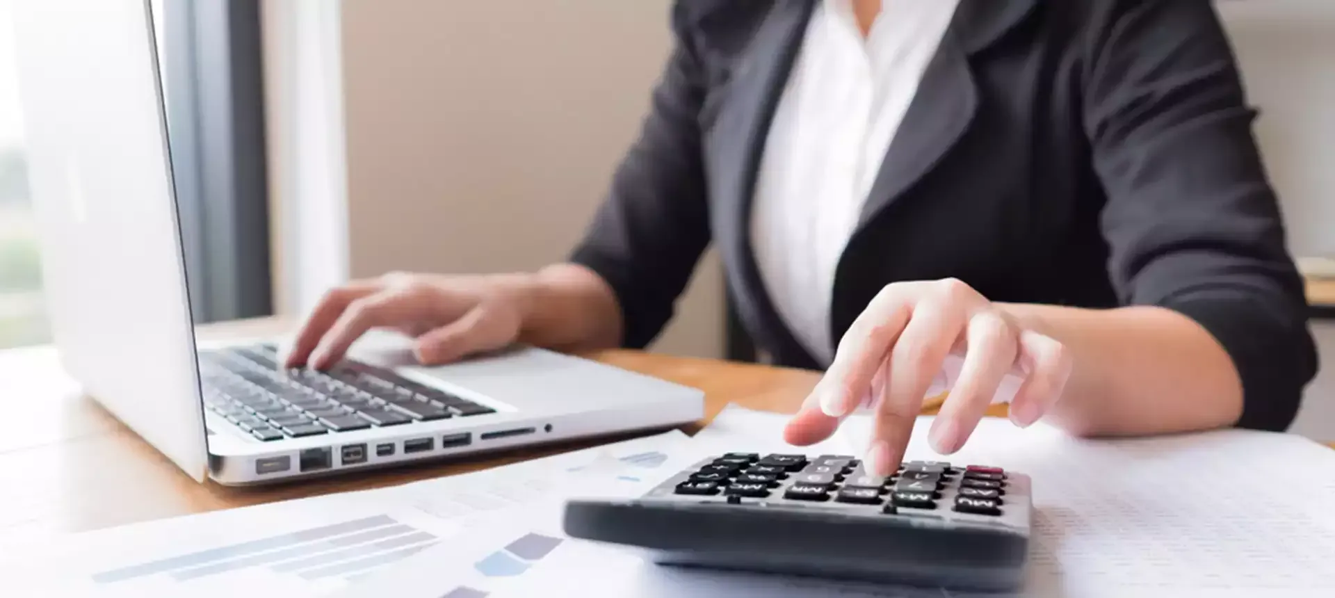 Woman is Using Laptop and Calculator — Rochdale Accounting & Business Advisory in Alstonville, NSW