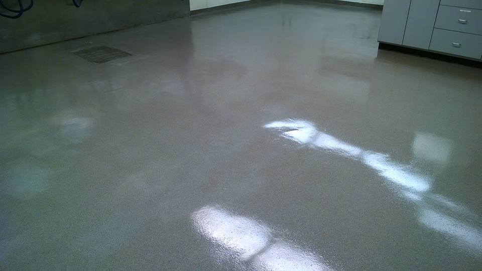 A light-gray, glossy floor reflects light in an interior space, likely a room or hallway.