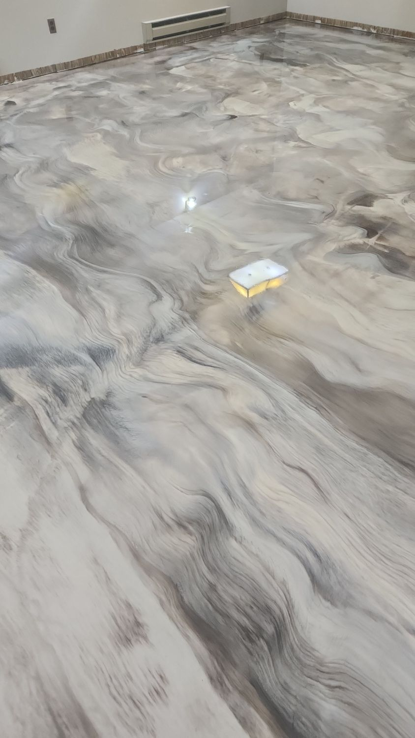 Metallic epoxy floor with swirled silver, gray, and brown tones.