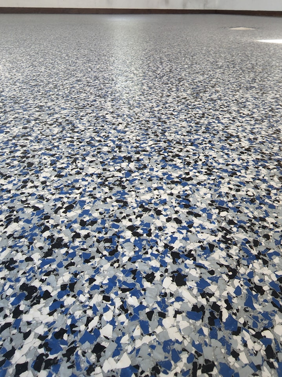 Floor with speckled blue, white, and black chips.