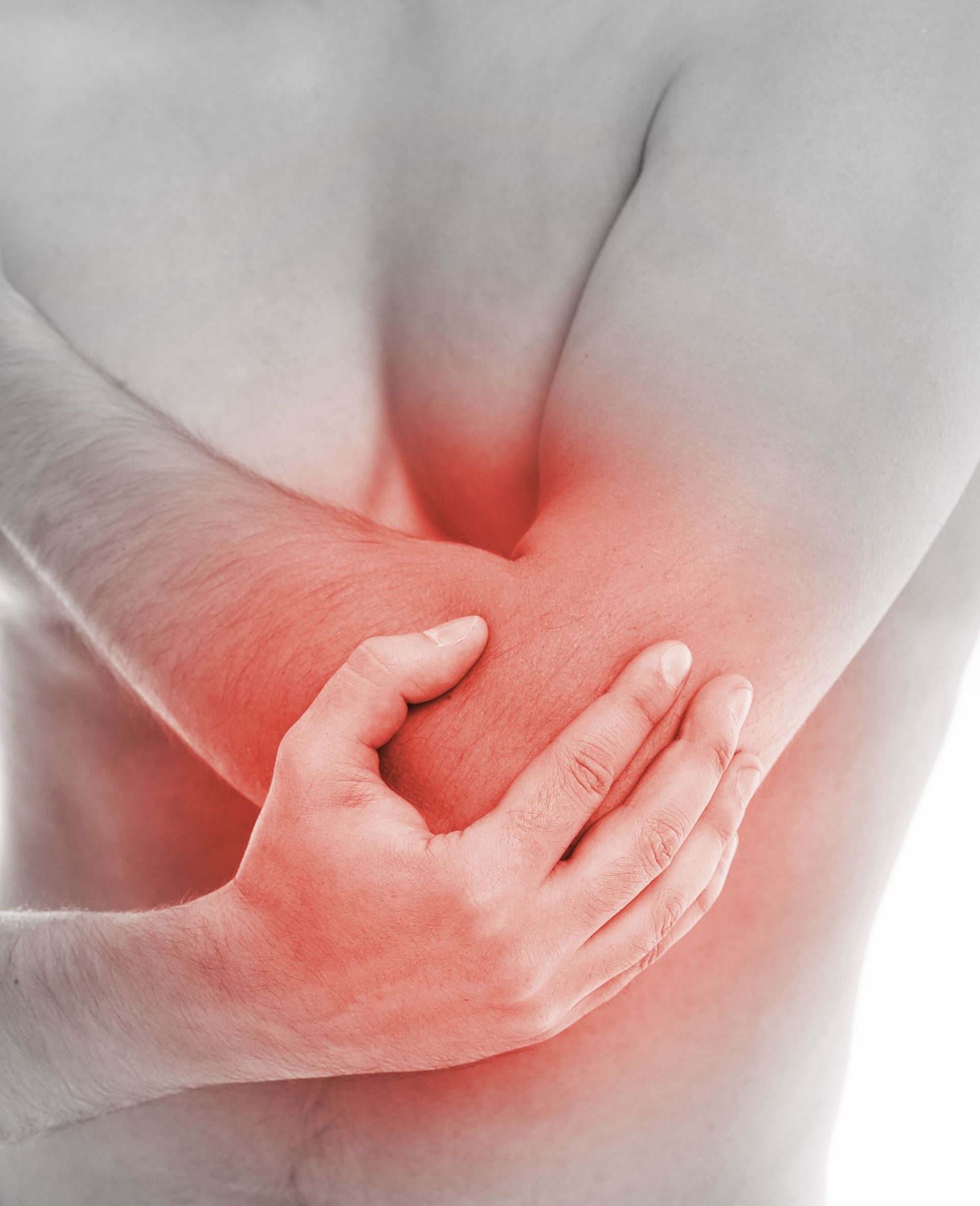 a man is holding his elbow in pain .