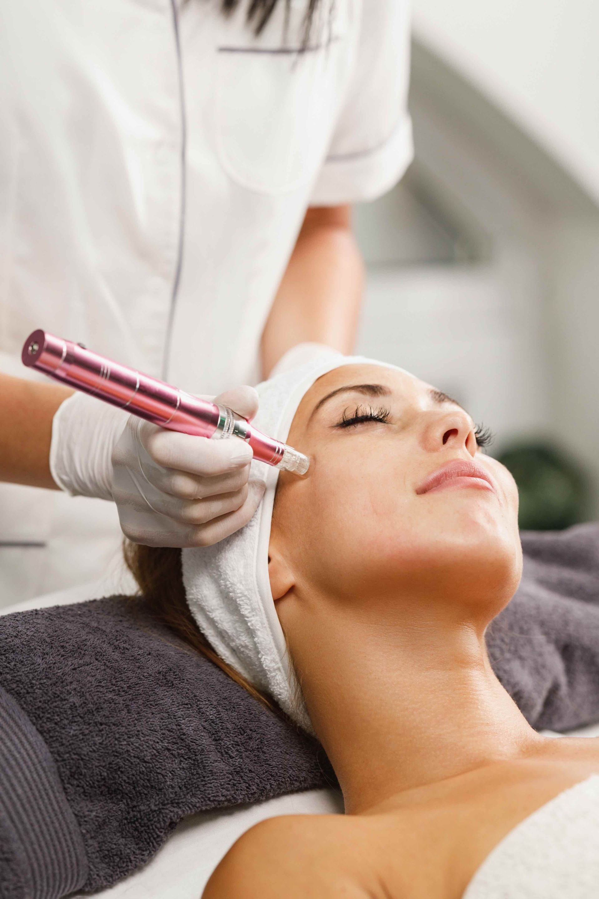 A woman is getting a microdermabrasion treatment on her face.