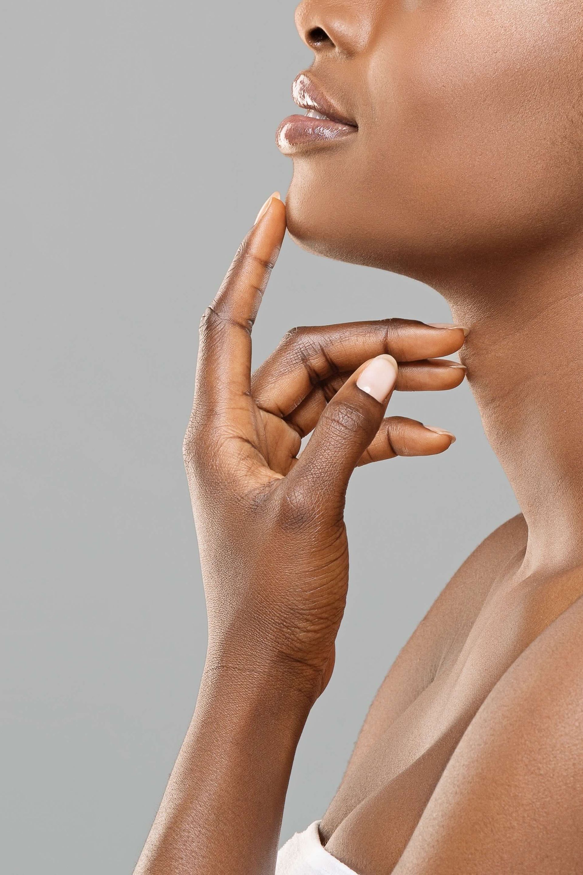 A close up of a woman 's face with her hand on her chin.