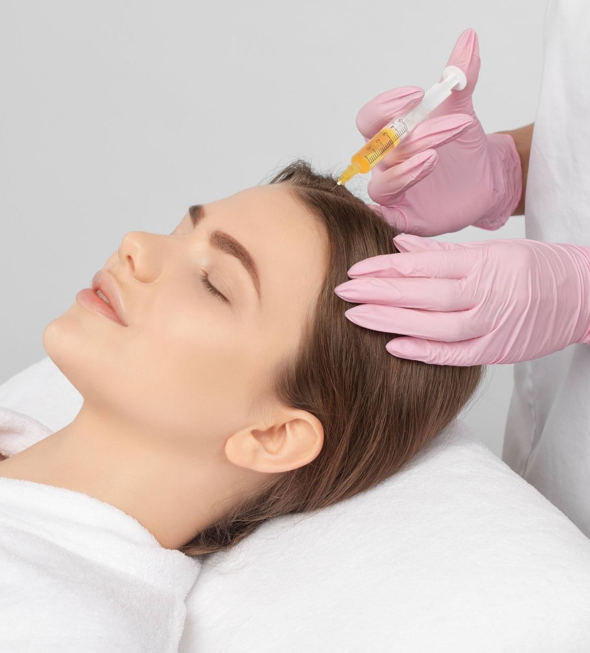 A woman is getting a botox injection in her head.