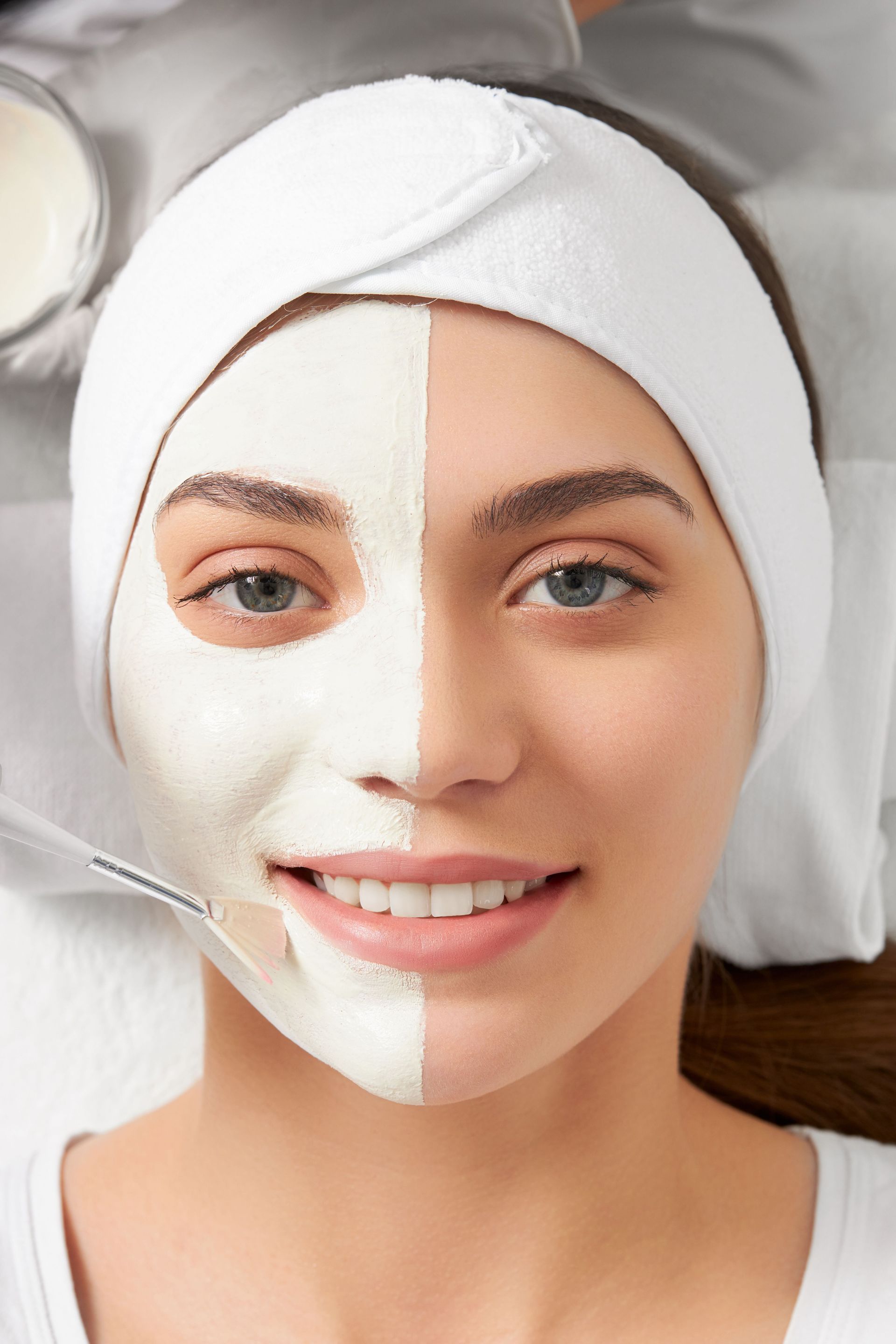 A woman with half of her face covered in a white mask