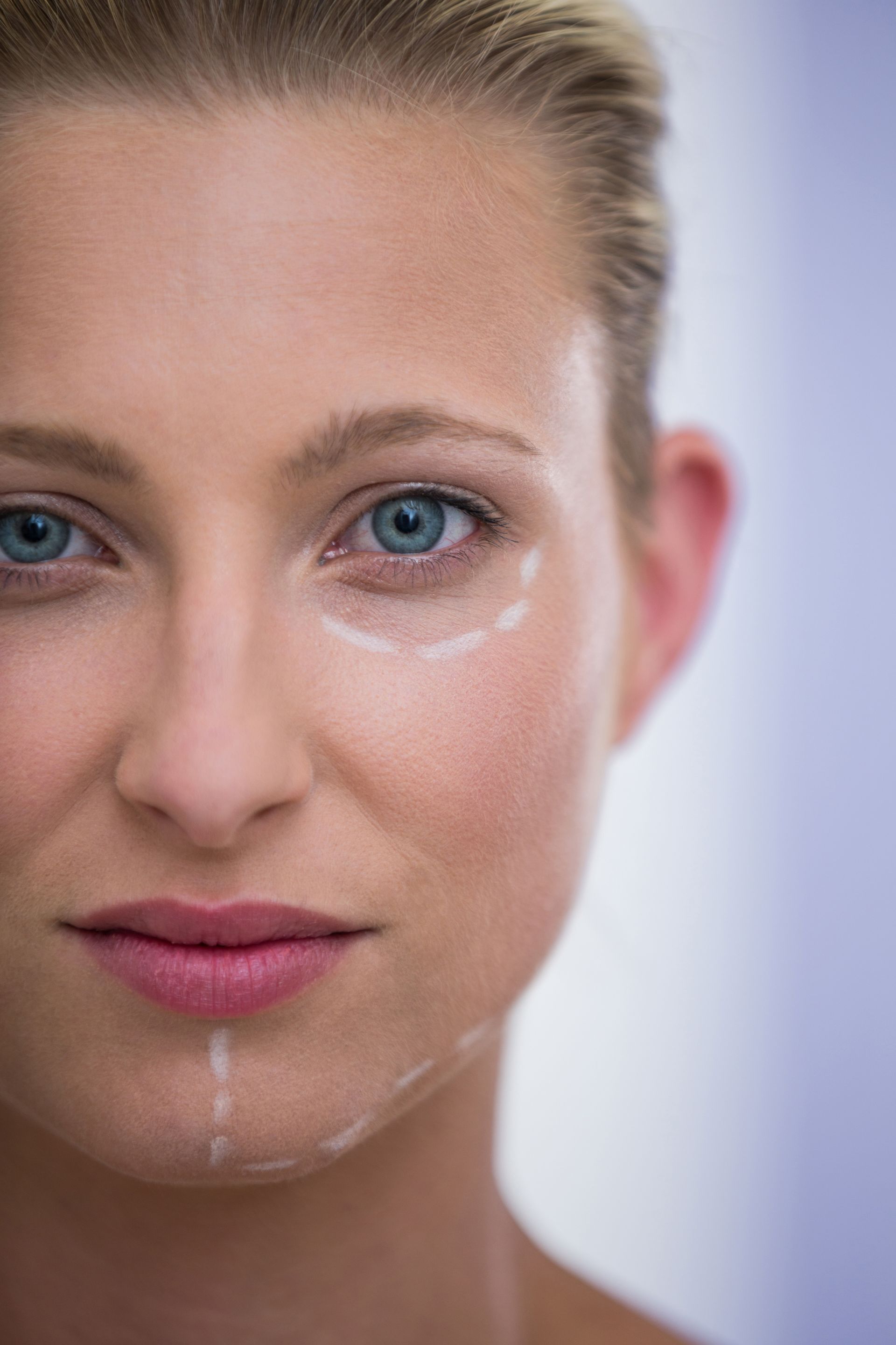 A close up of a woman 's face with lines drawn on it.