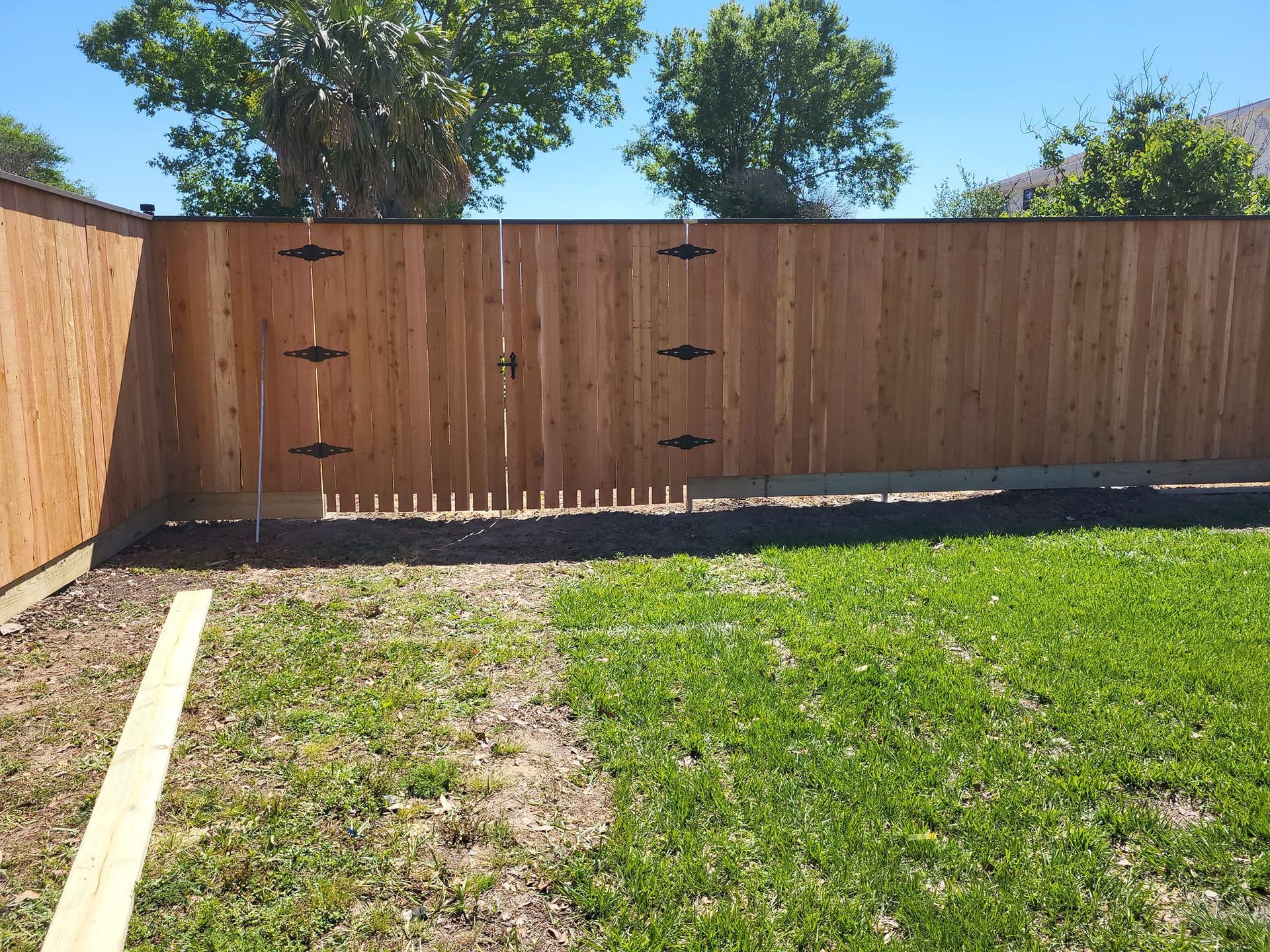 A wooden fence with a gate in the backyard