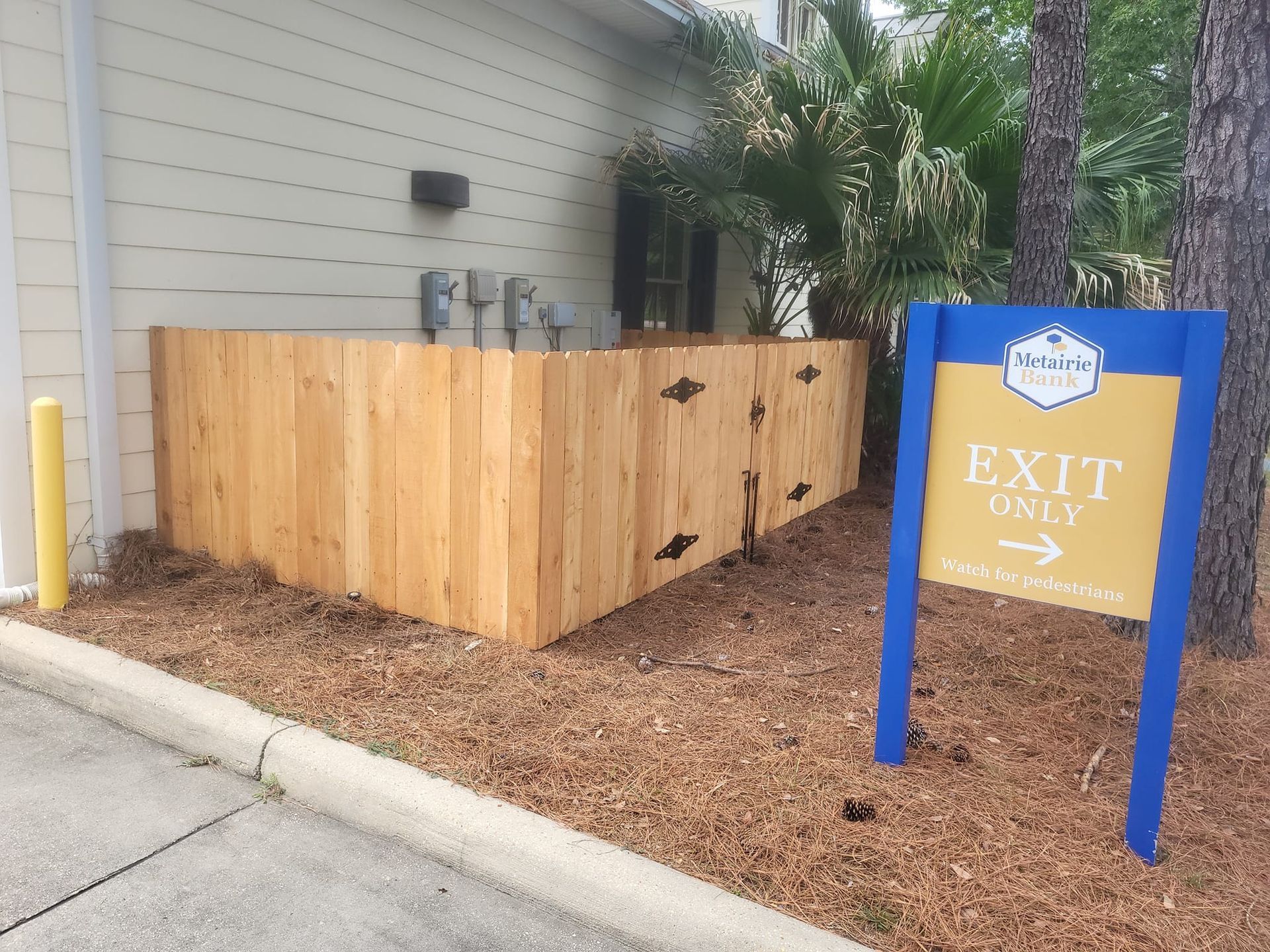 A wooden fence next to a sign that says exit only
