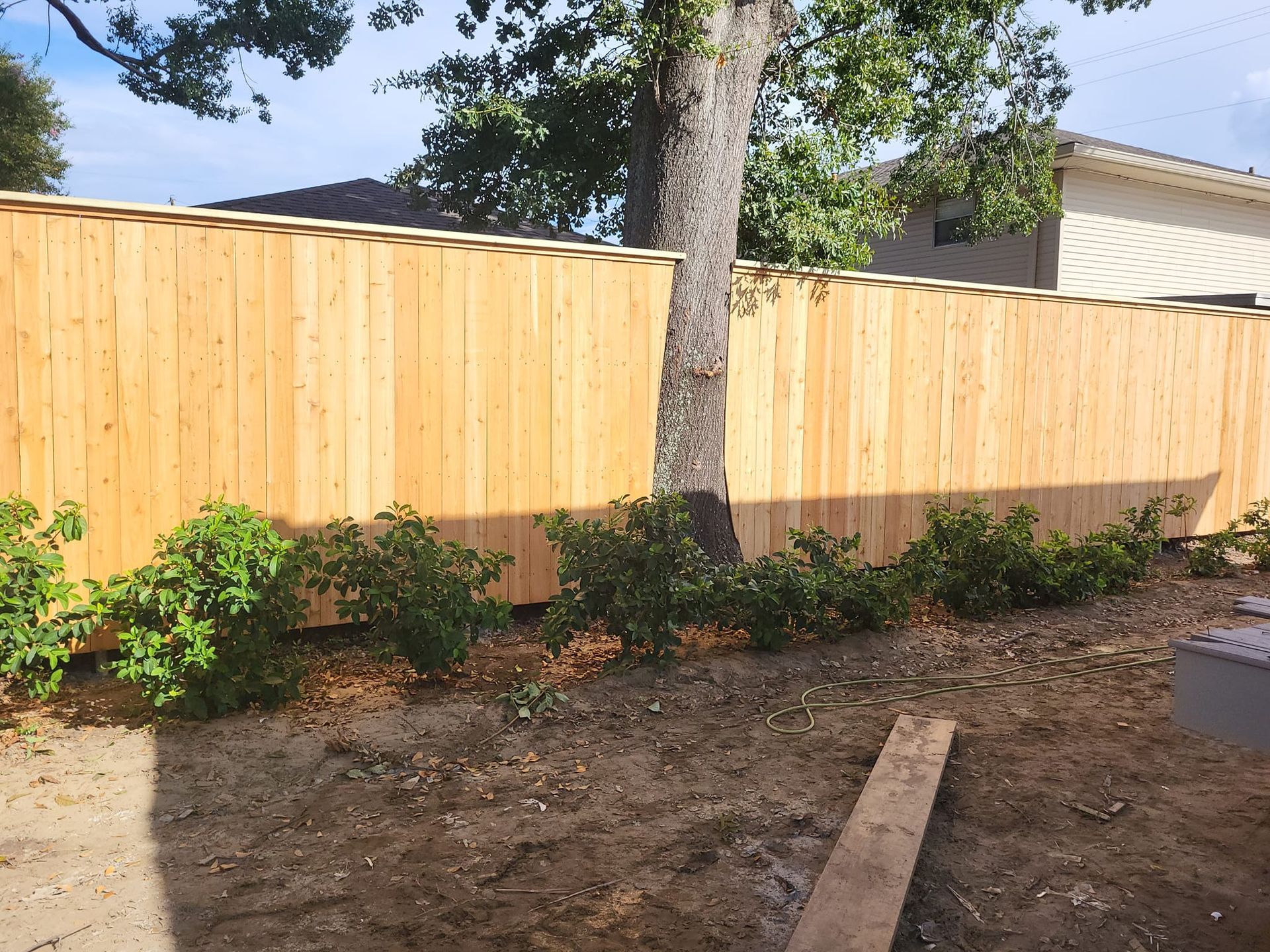 A wooden fence with a tree in the background
