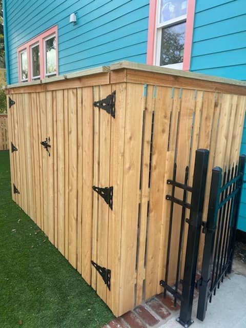 A wooden fence is in front of a blue house