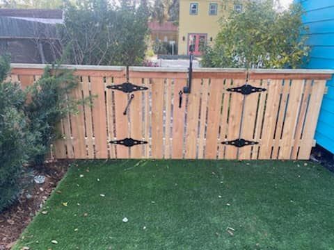A wooden fence is sitting on top of a lush green lawn.