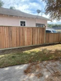 A wooden fence is sitting in front of a house.