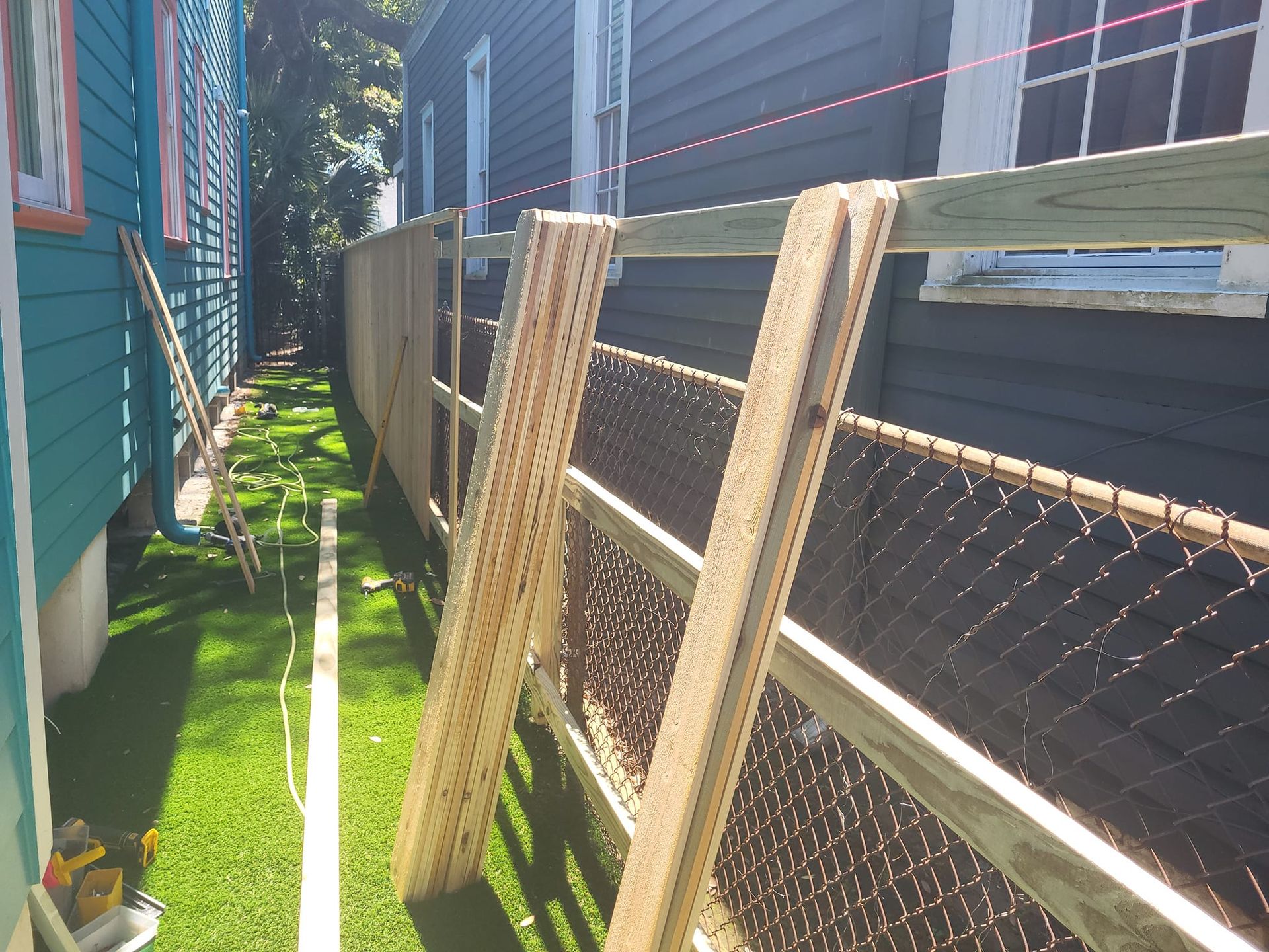 A wooden fence with a chain link fence behind it