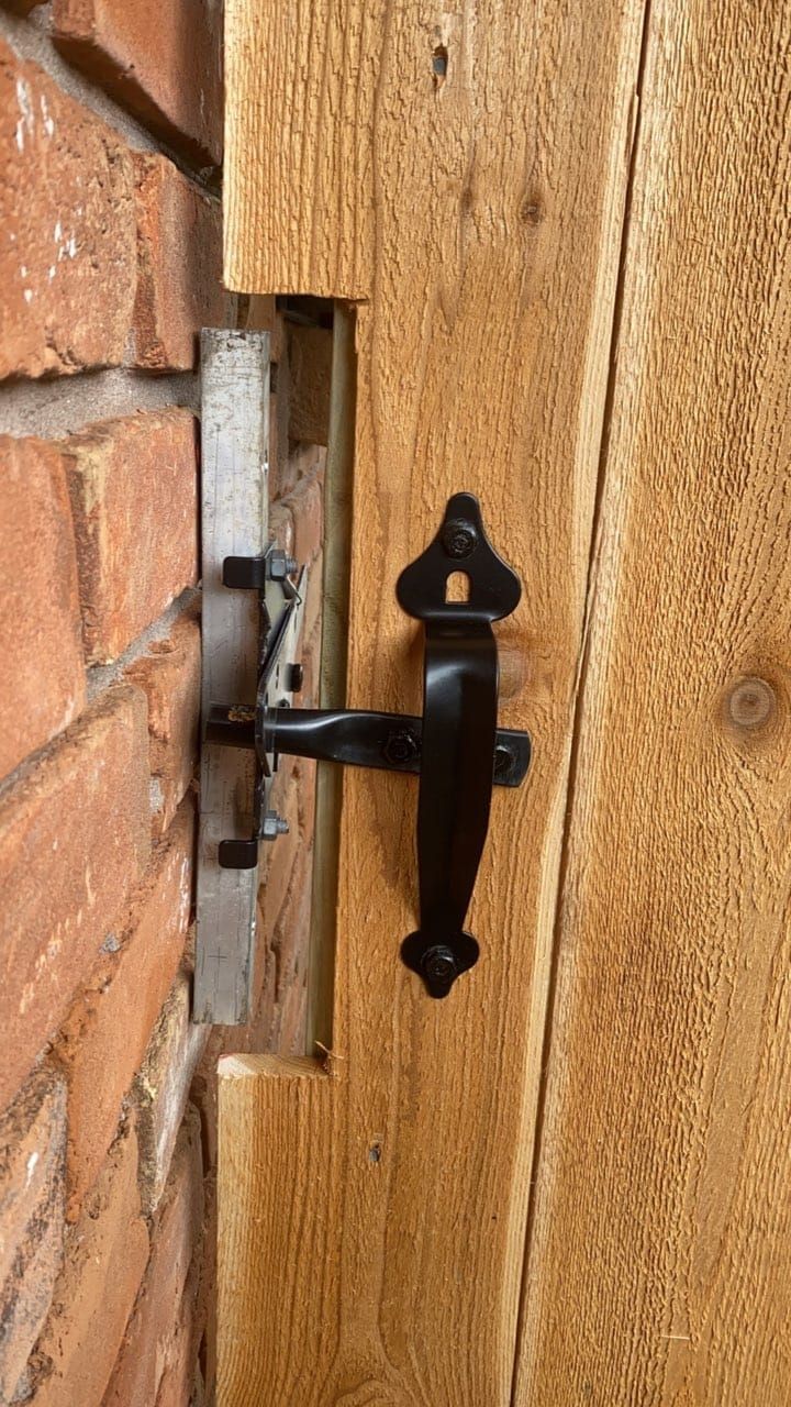 A close up of a door latch on a wooden door.