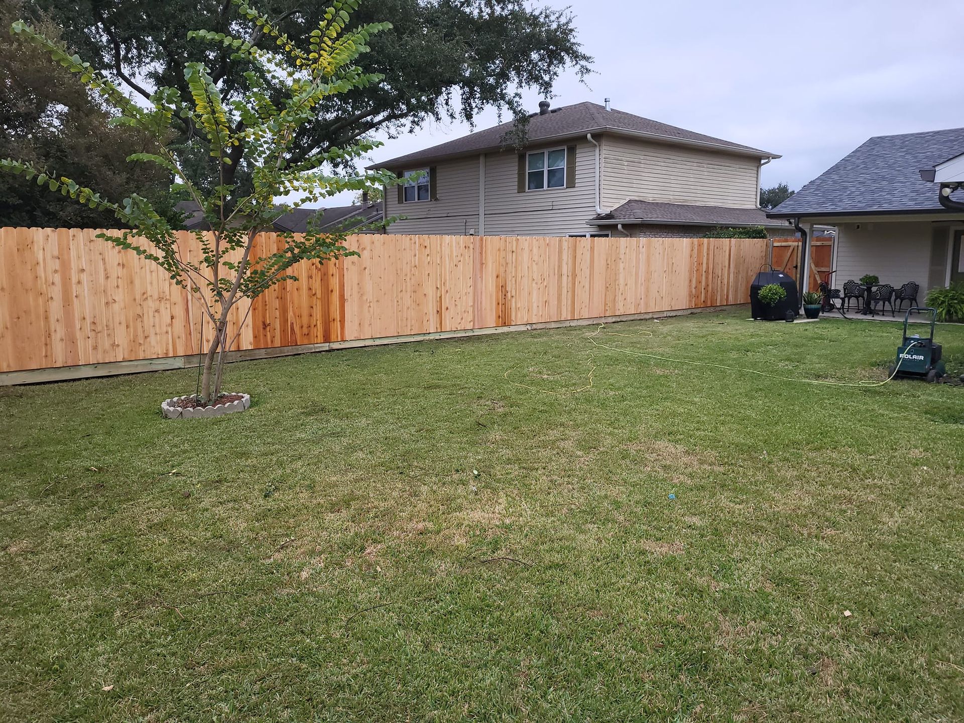 There is a wooden fence in the backyard of a house.
