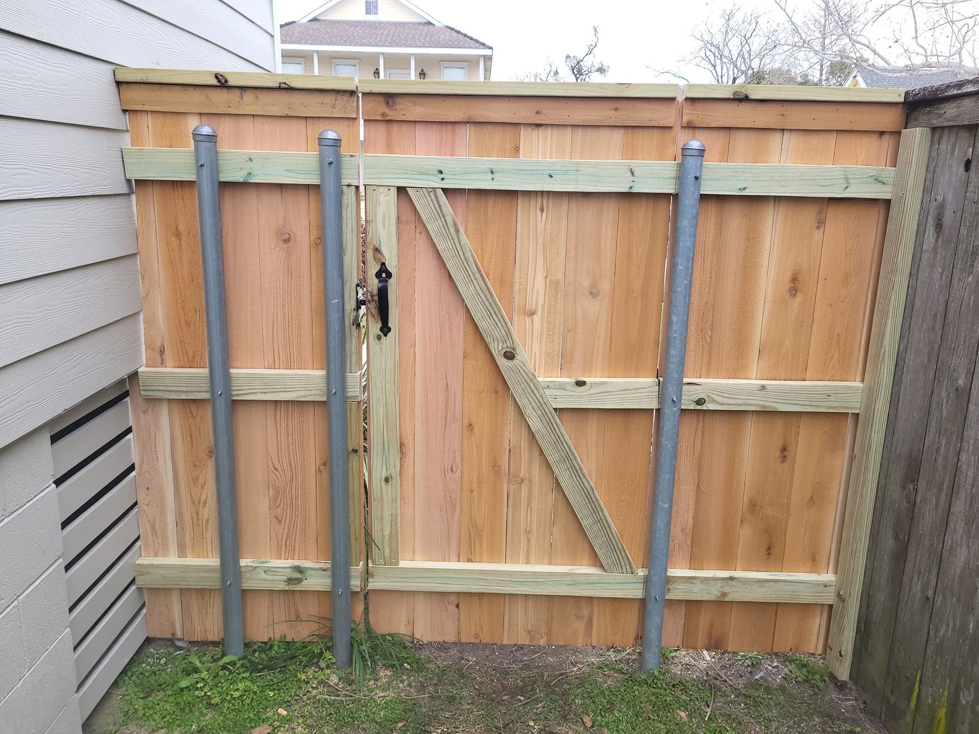 A wooden fence with a gate in the backyard