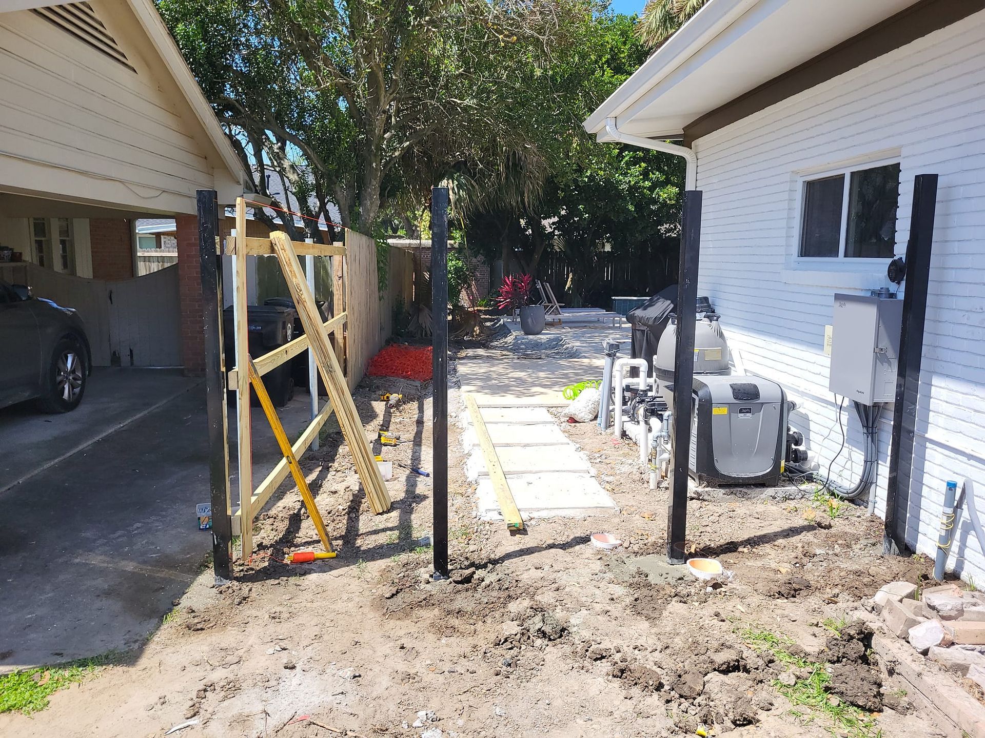 A fence is being built in the backyard of a house.