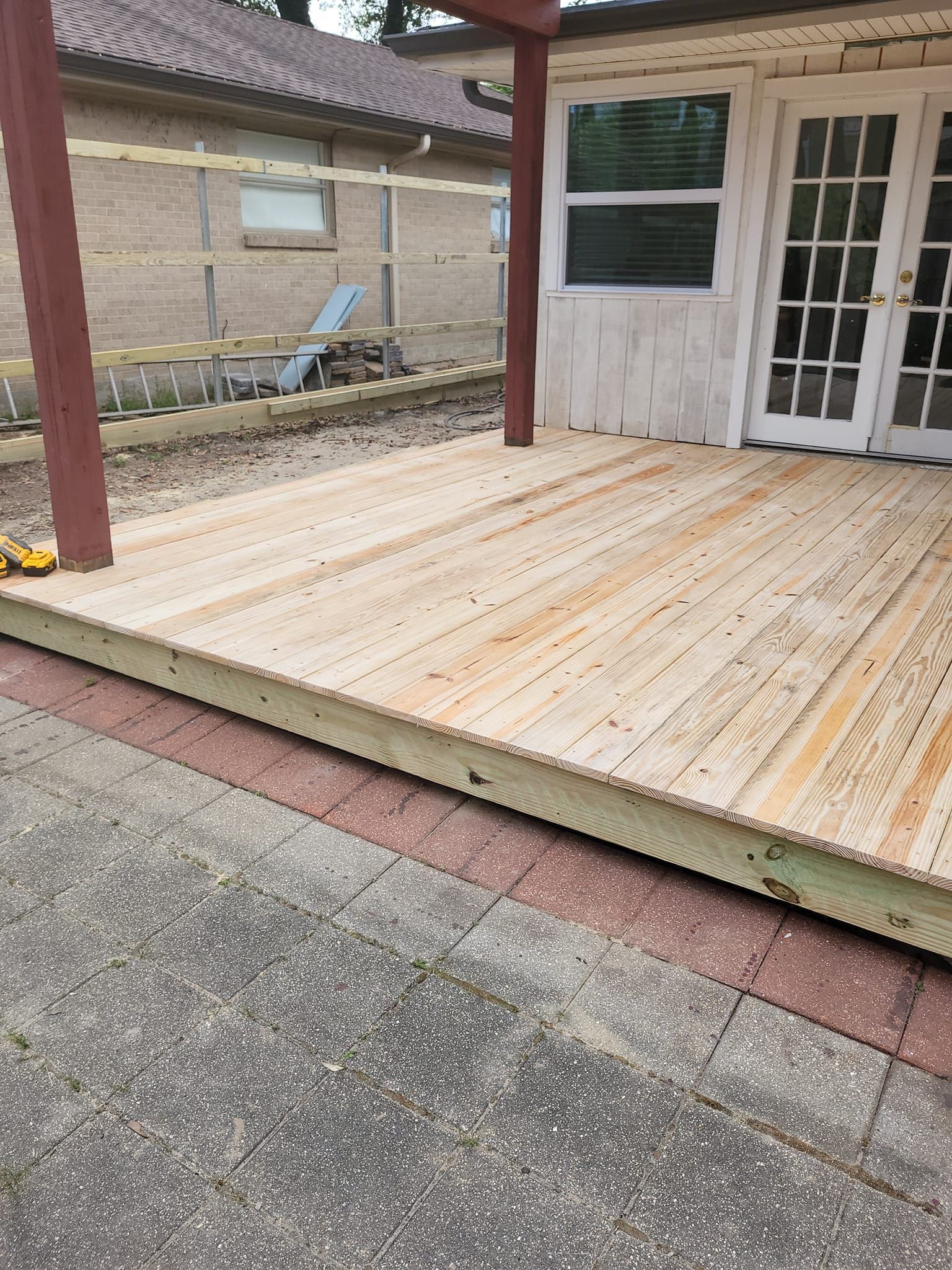 A wooden deck is being built in front of a house.