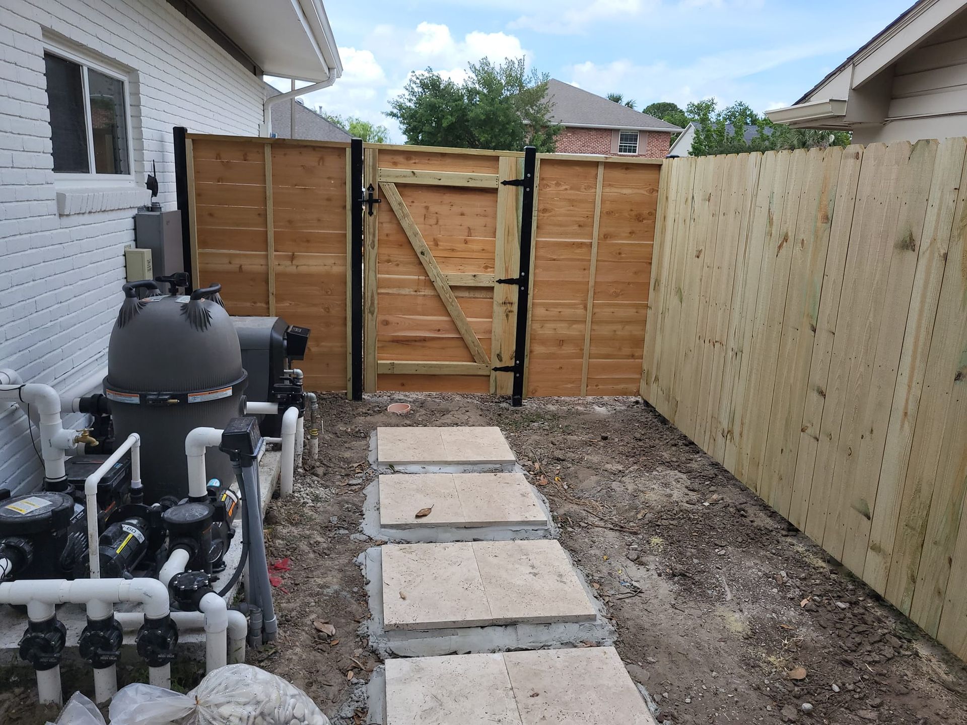A backyard with a wooden fence and a gate