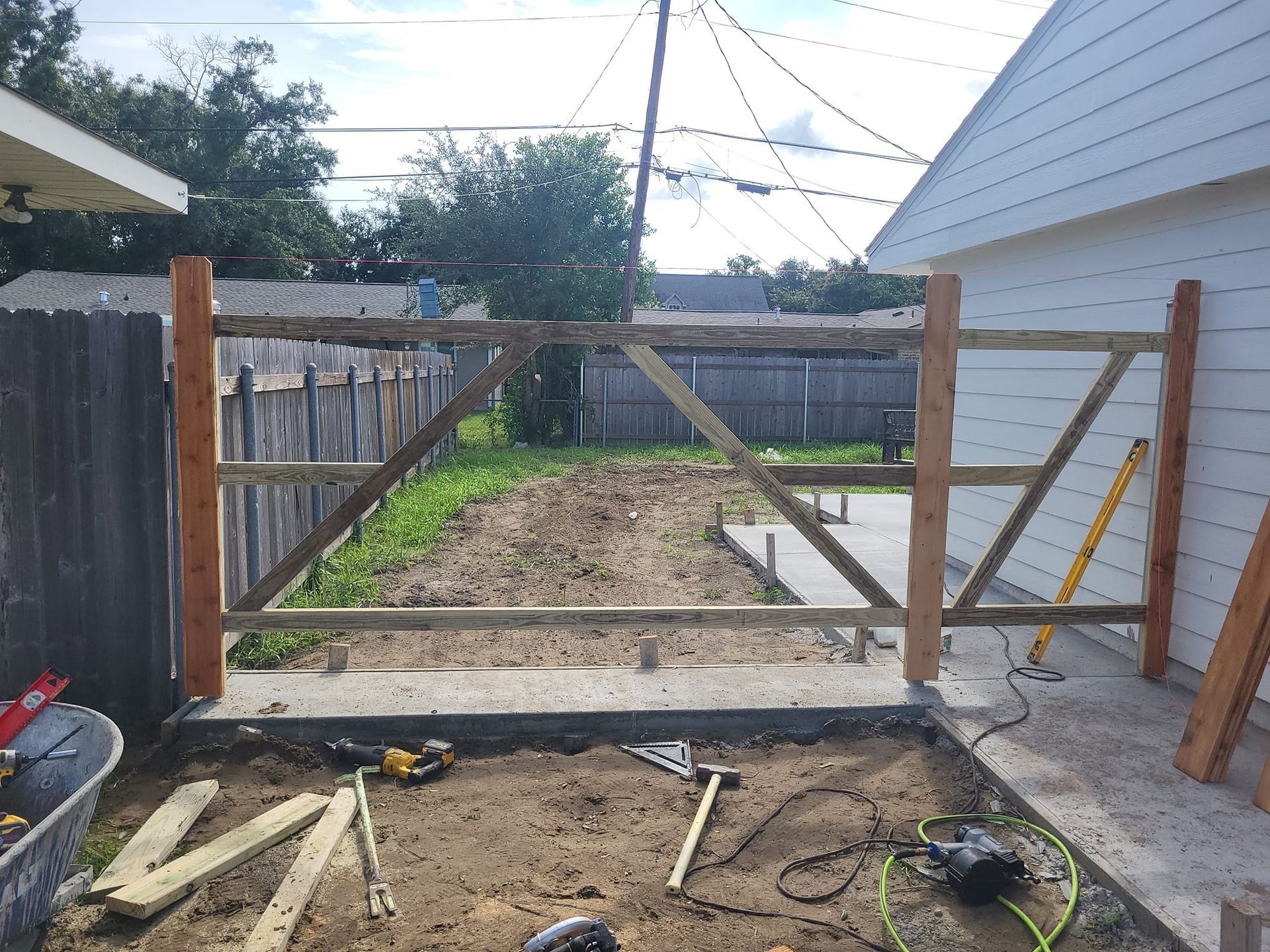 A wooden gate is being built in the backyard of a house
