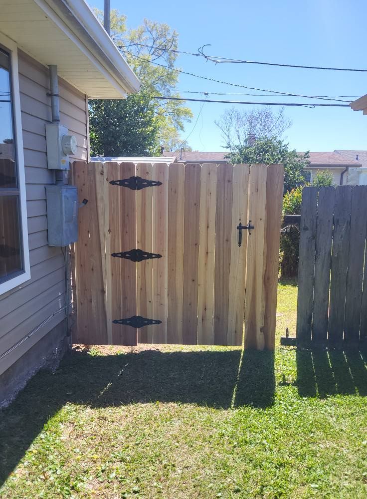 A wooden gate is in the backyard of a house.