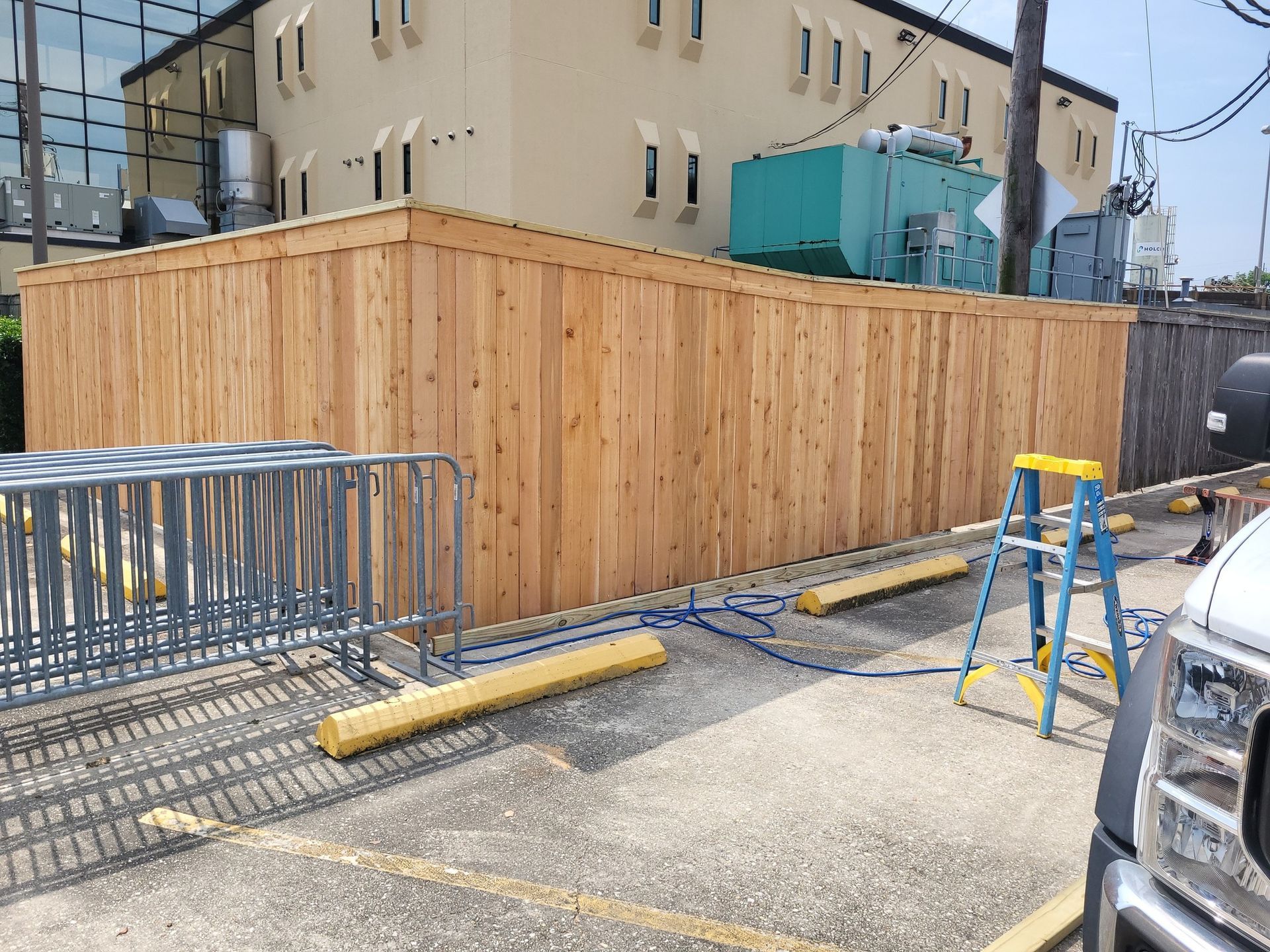 A wooden fence is being built in front of a building.