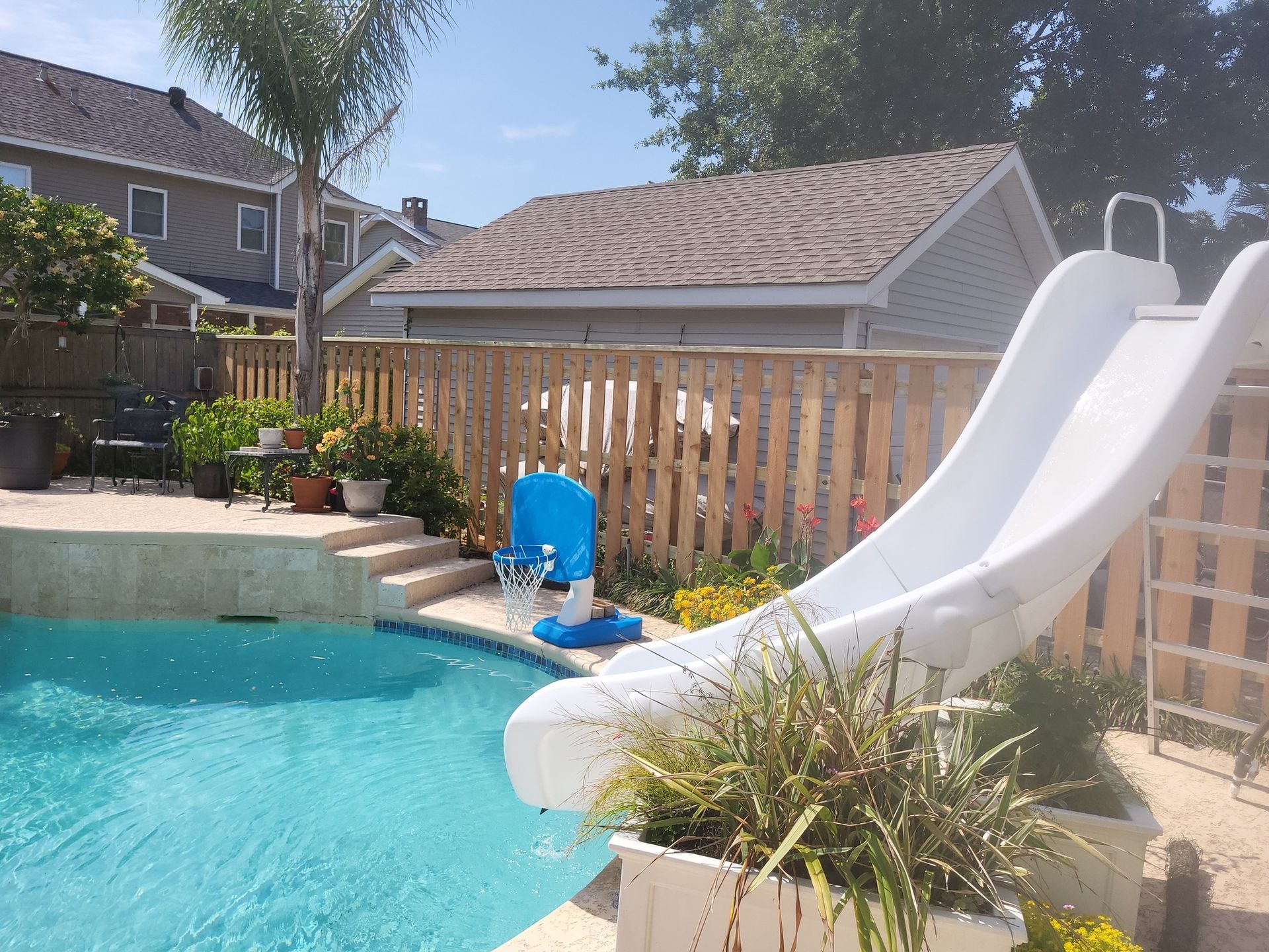 A swimming pool with a slide in the backyard