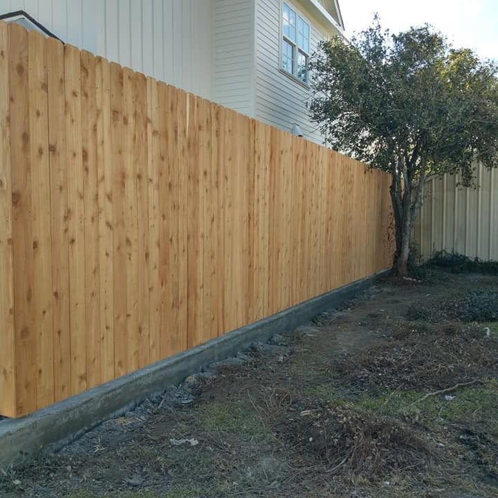 A wooden fence with a house in the background