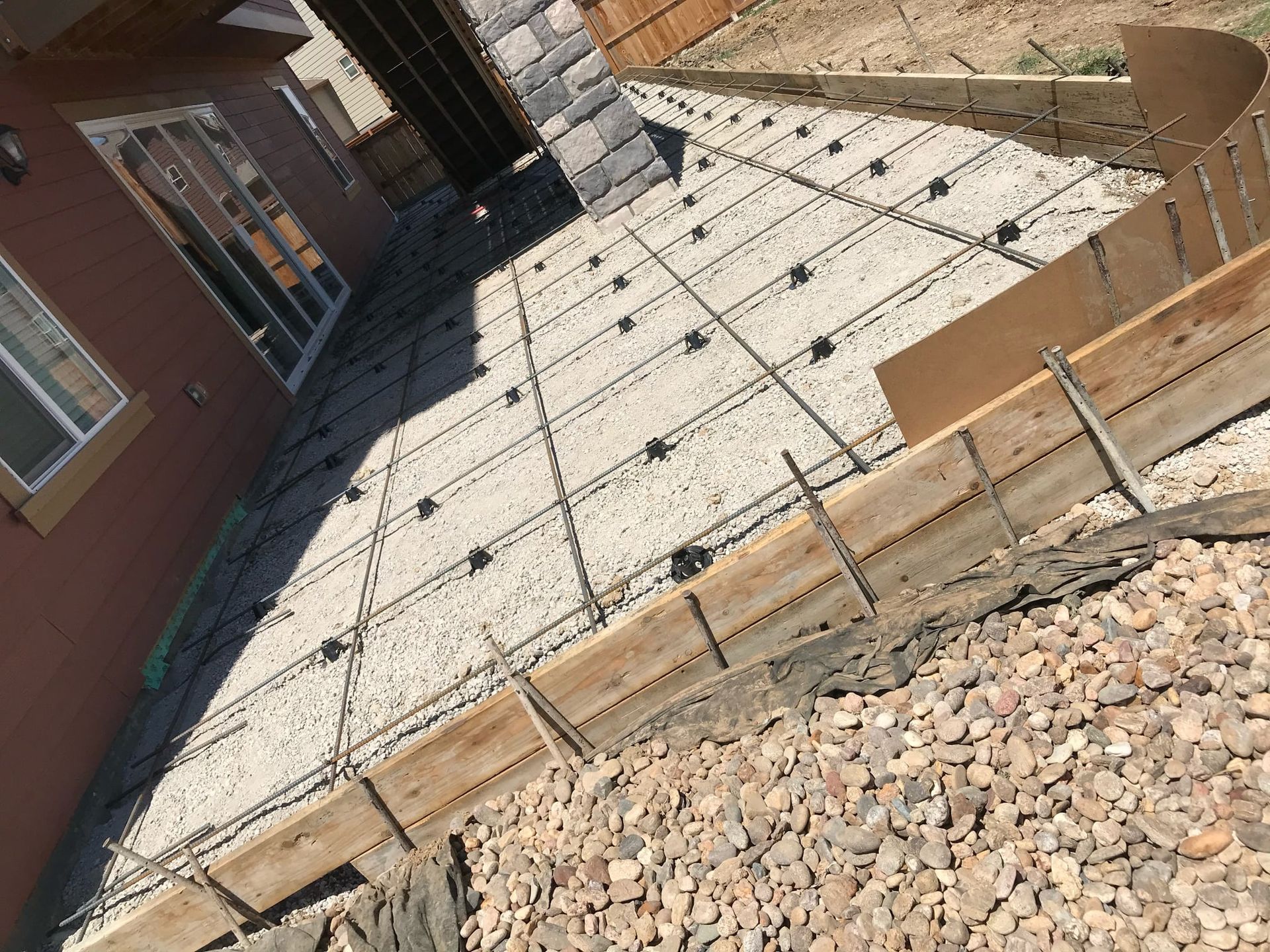 A concrete walkway is being built in front of a house.