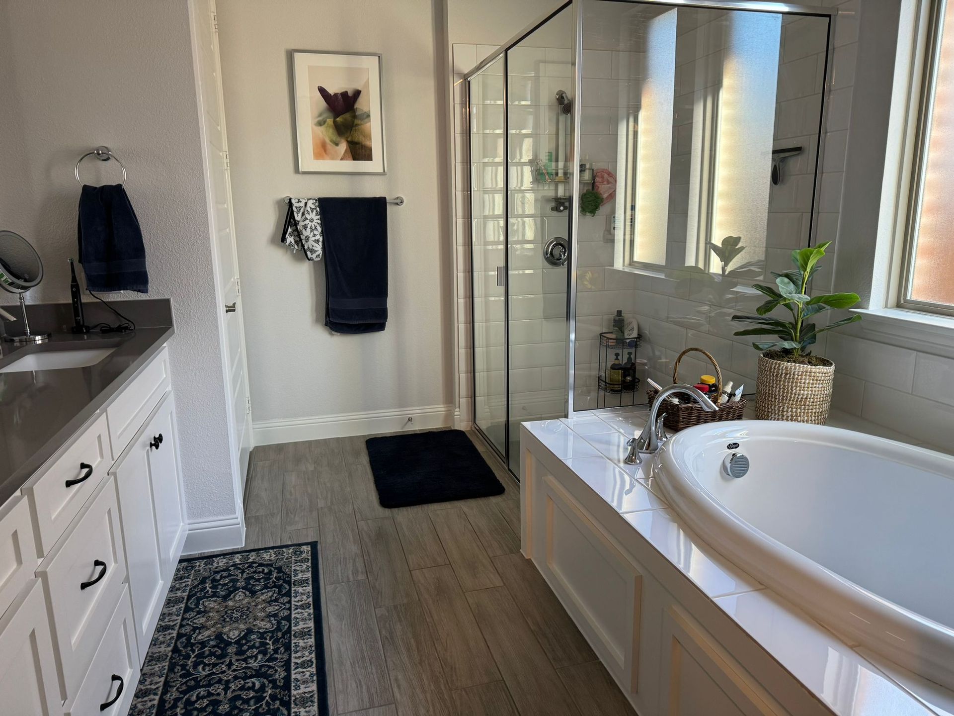 A bathroom with a tub , sink , and shower.
