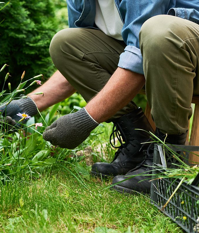 Person gardening while seated on a stool, using adaptive positioning to protect joints