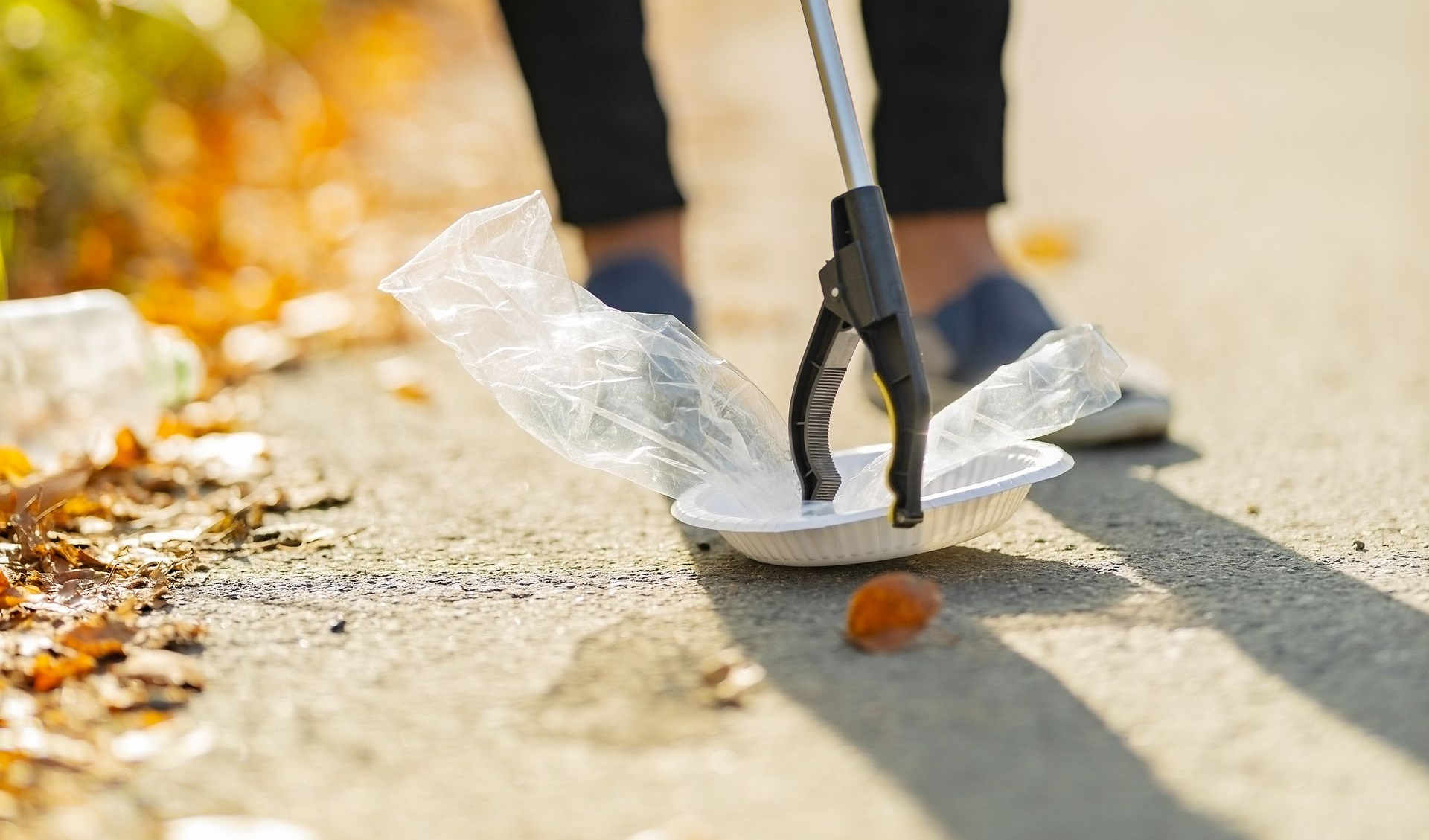 Energy conservation and adaptive equipment Person using a reacher tool to pick up an item, demonstrating energy conservation during daily tasks