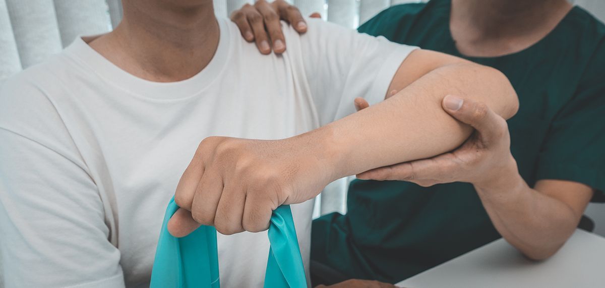 Beginning treatment with a therapeutic exercise Therapist guiding a patient through a resistance band exercise during an occupational therapy session