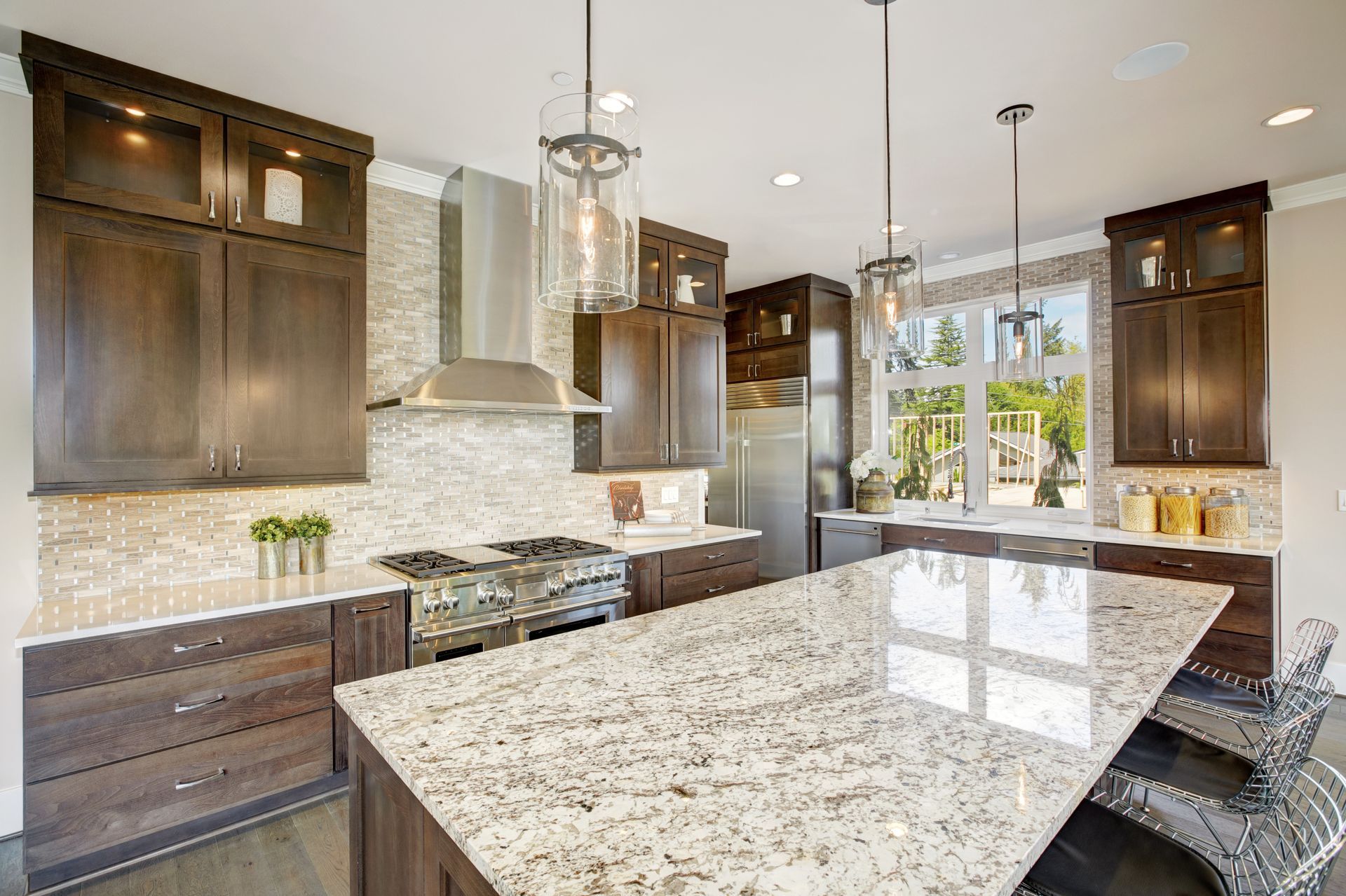 Modern kitchen with dark wood cabinets, granite countertops, stainless steel appliances, and pendant lights. Modern kitchen with dark wood cabinets, granite countertops, stainless steel appliances, and pendant lights.