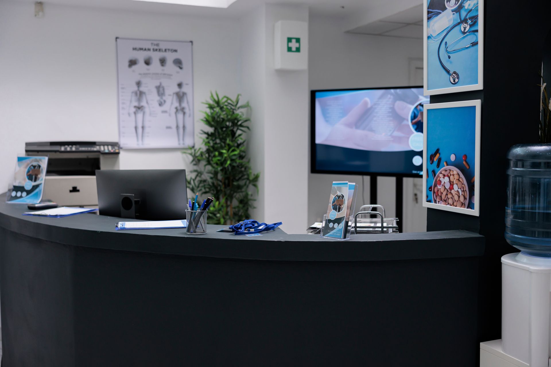 Reception desk with computer, posters, and water cooler.