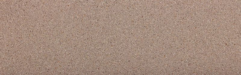 Close-up of a textured, light brown surface with tiny darker speckles.