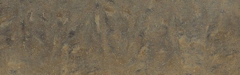 Close-up of a textured surface, primarily brown with darker and lighter tones, resembling stone or rock.