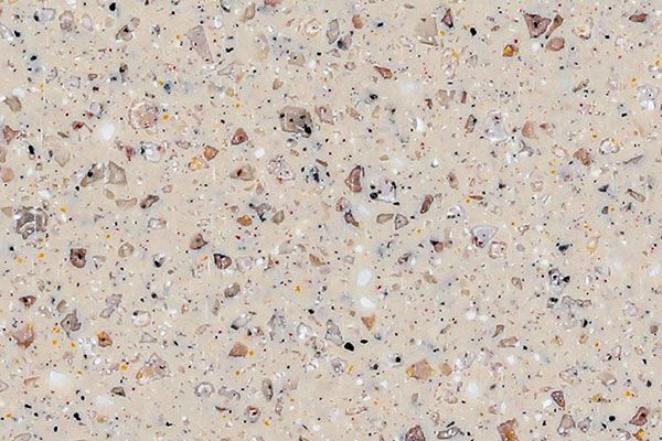 Beige speckled surface with various colored flecks, likely a countertop material.