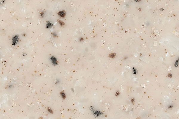 Beige speckled countertop with dark and light flecks.