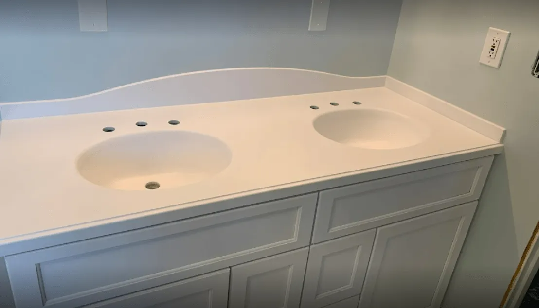 White double sink vanity with white countertop in a bathroom with pale blue walls.