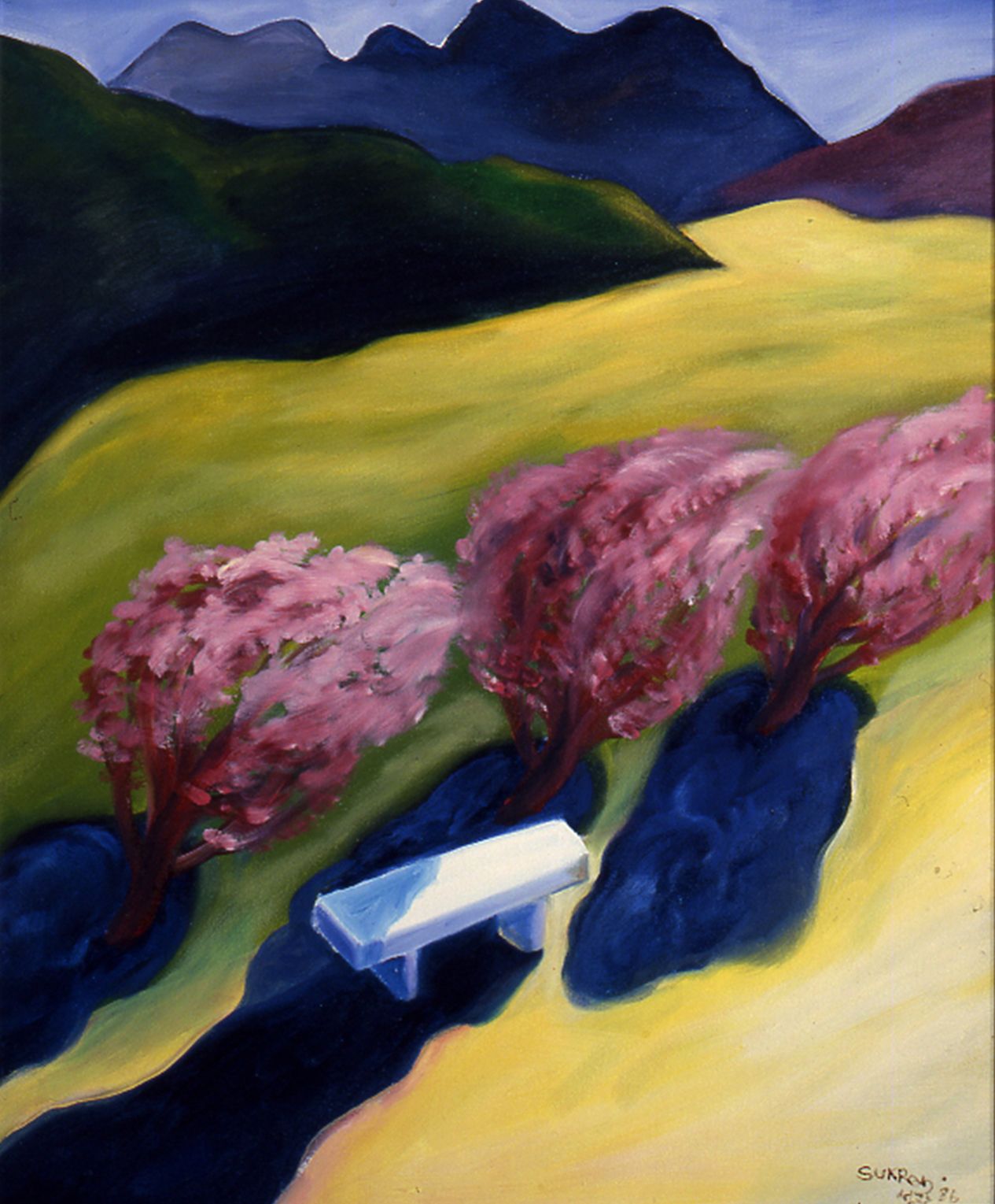 White truck on a winding road beside pink trees, with mountains and yellow fields in the background.