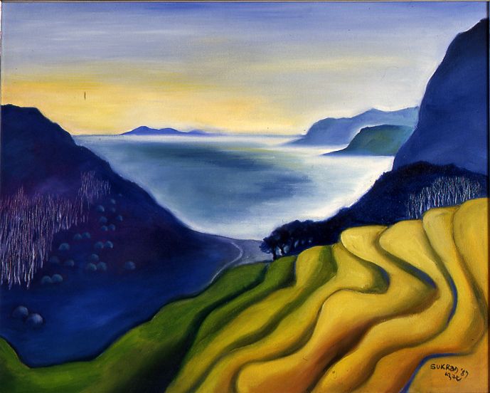 Yellow terraced hills overlooking a blue bay and distant mountains at sunset