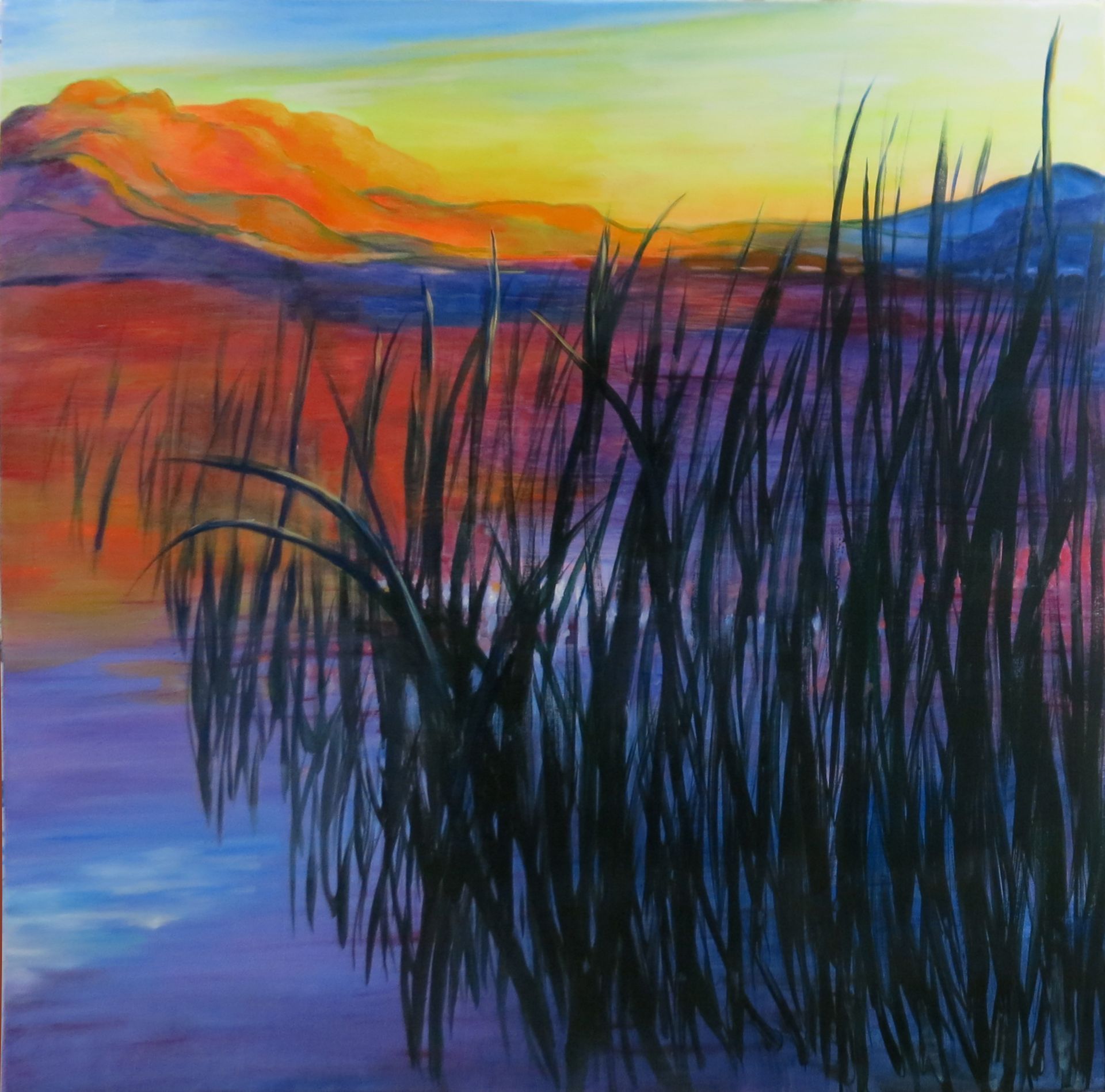 Abstract sunset over water with orange and blue sky, mountains, and dark reeds in the foreground