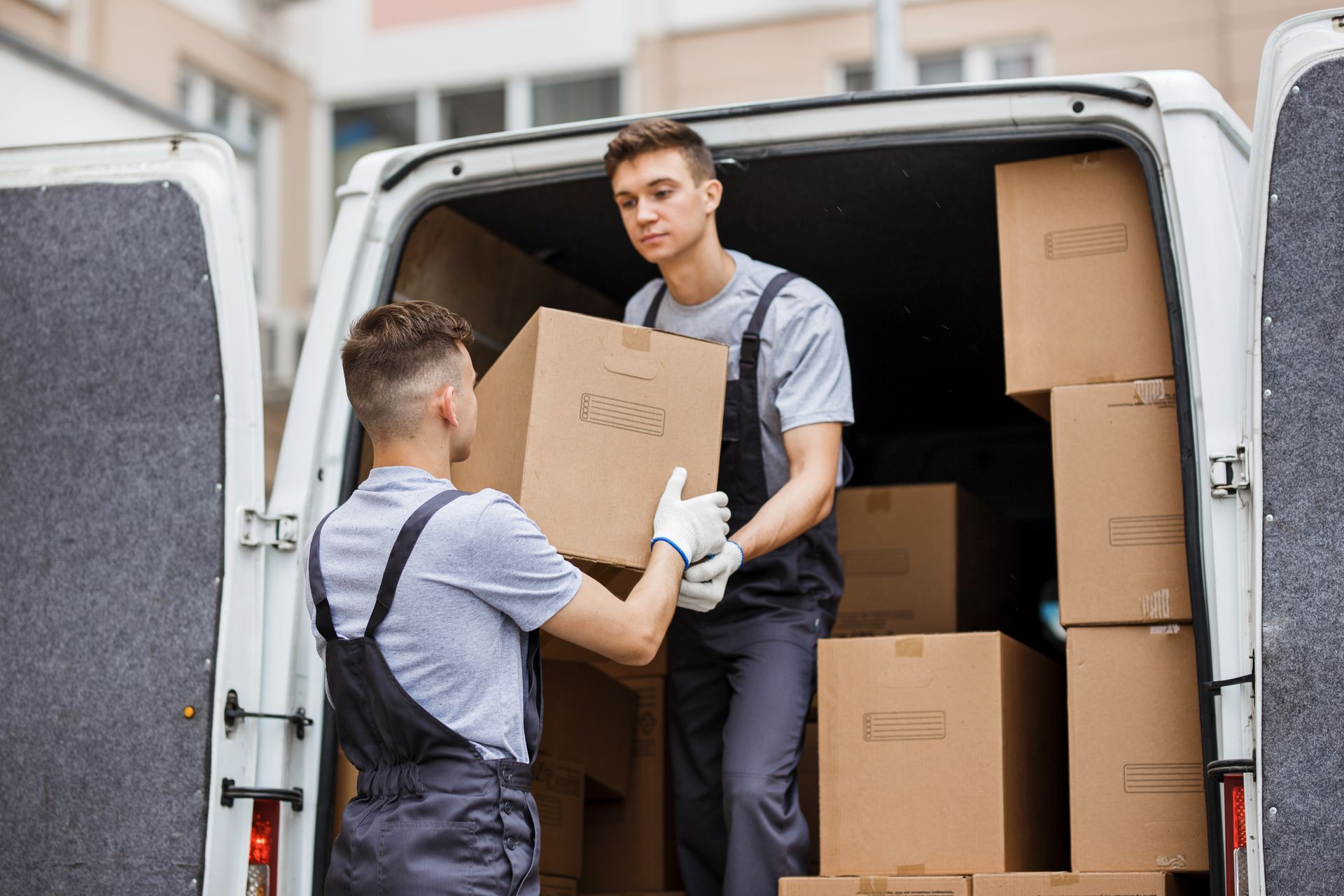 Professional movers loading boxes and furniture into a moving truck. Professional movers loading boxes and furniture into a moving truck.
