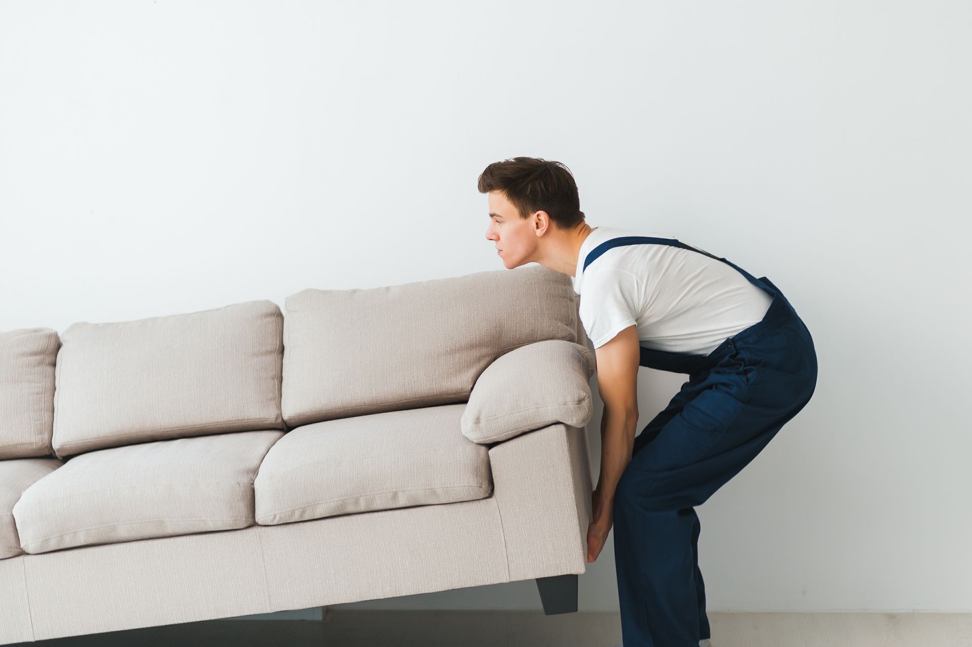 Professional mover carrying a sofa during a local home move in Rogers, Arkansas