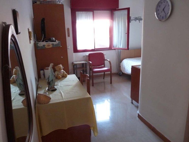 Una stanza con tavolo e sedie e un orologio sul muro