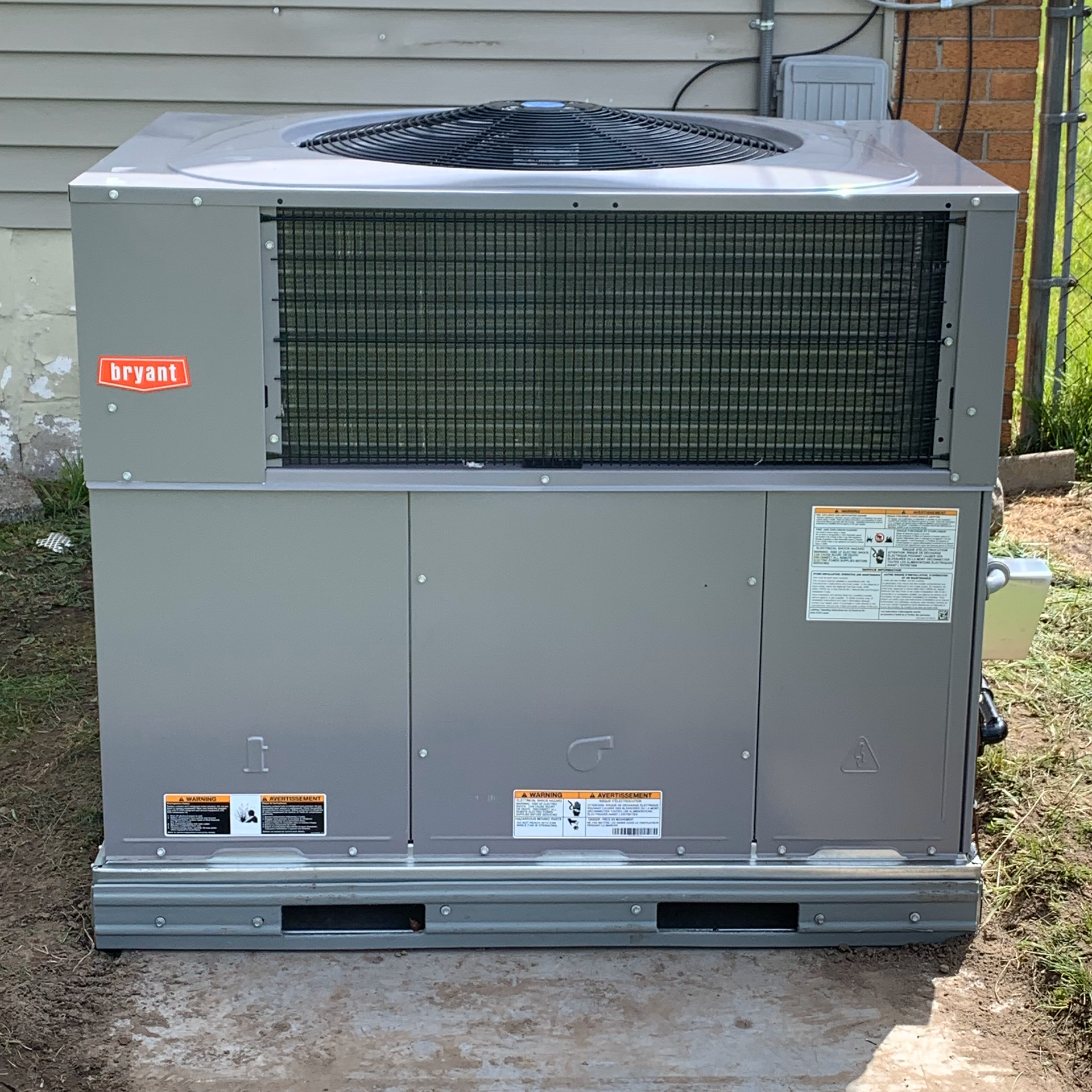 Gray Bryant air conditioning unit outside a building.