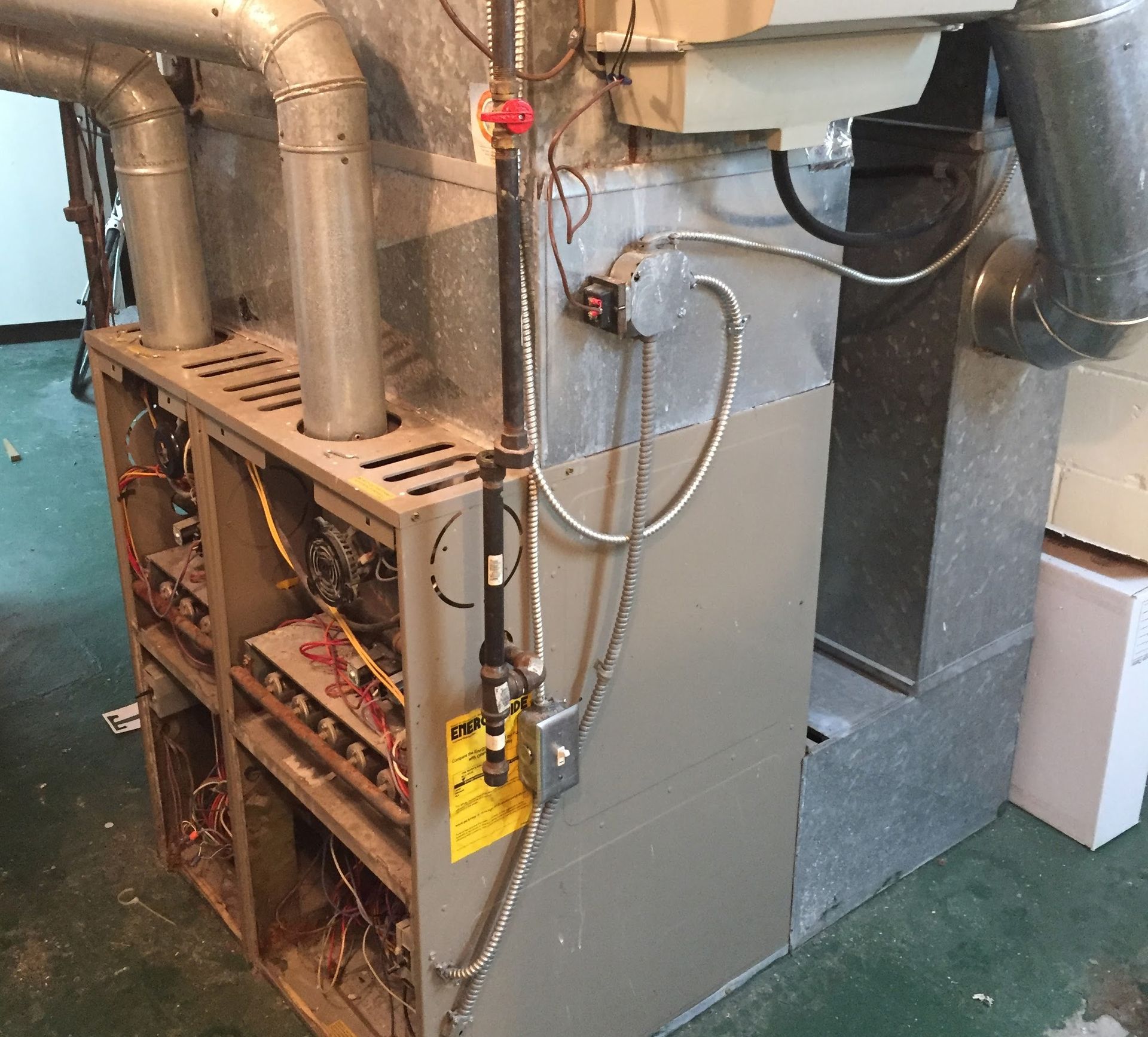 Furnace with open panels, showing internal components and ductwork.