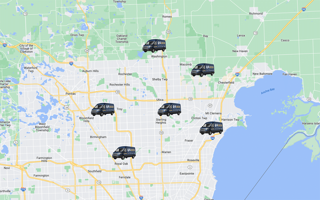 Map with six black car icons marking locations across a city area near a large lake